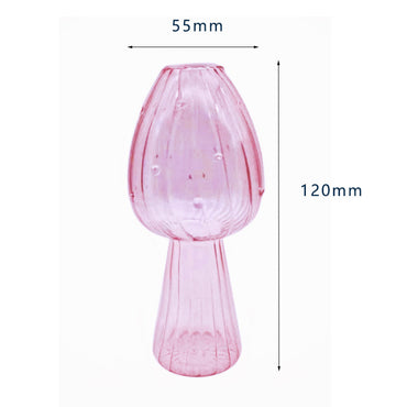 Clear glass mushroom-shaped vase with hydroponic plant and flowers on a minimalist home table

