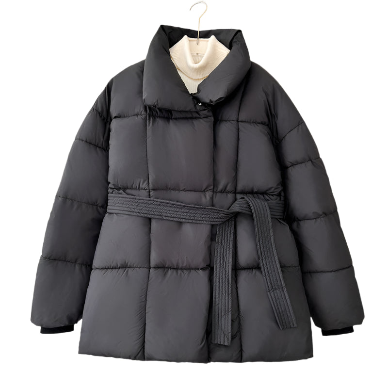 Model wearing a short tie-waist puffer jacket with a stand collar and boots