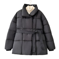 Model wearing a short tie-waist puffer jacket with a stand collar and boots