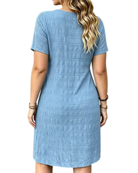A woman shown from the back wearing a light blue short-sleeve textured dress against a plain white background.