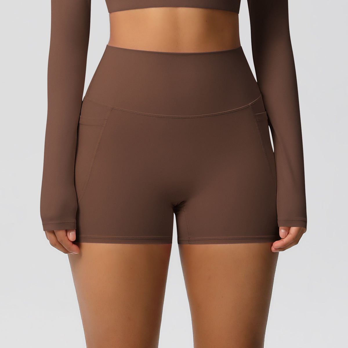 Brown athletic outfit with shorts and long-sleeve top on a plain background