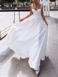 A stylish sexy sling wedding dress featuring a sleek silhouette, delicate straps, and a flowy design, perfect for modern brides.

