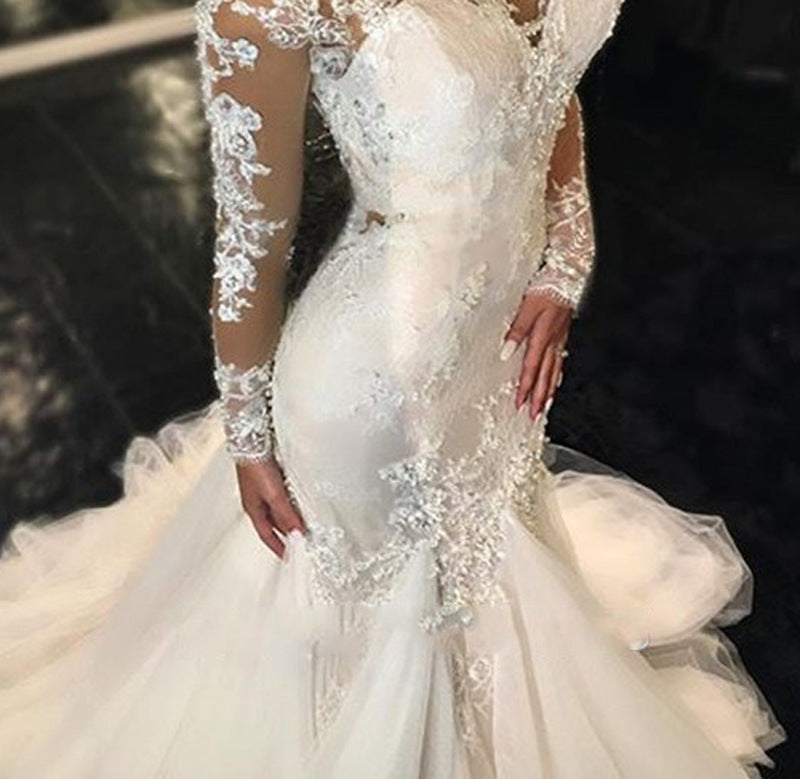 A trailing white lace wedding dress with a slim fit and elegant design, featuring intricate lace details for a timeless bridal look.

