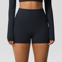 Person wearing black athletic shorts and long-sleeve top on a light gray background