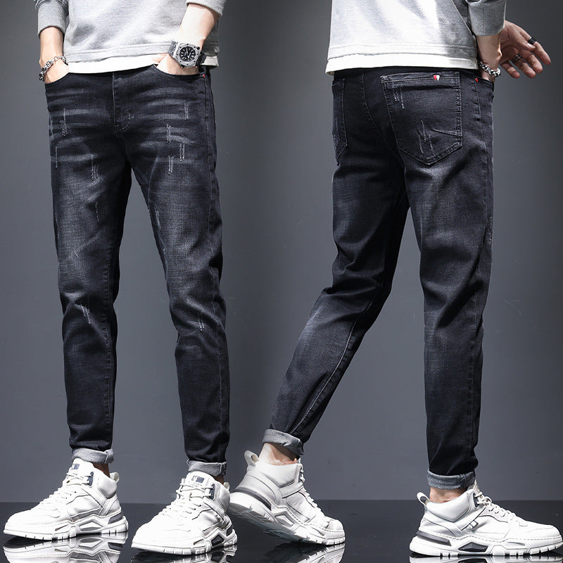Men's ripped denim jeans with cat-whisker scratch detailing and distressed finish
