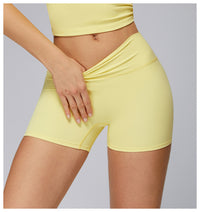 Person wearing yellow athletic shorts and top on a gray background