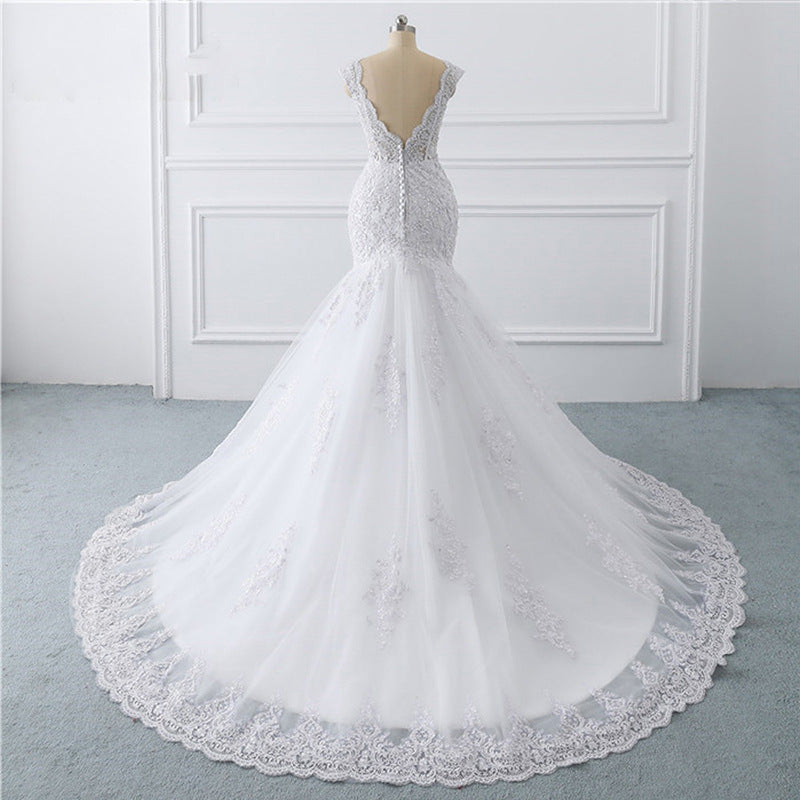 A luxurious mermaid wedding dress with a light trailing train, French retro design, and delicate lace details, perfect for an elegant and slim bridal look.

