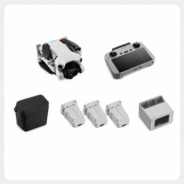 A set of drone accessories arranged on a light gray background, including a folded white drone with black and orange accents, a gray remote controller with a screen, a black carrying case, three light gray battery packs, and a gray charging dock.