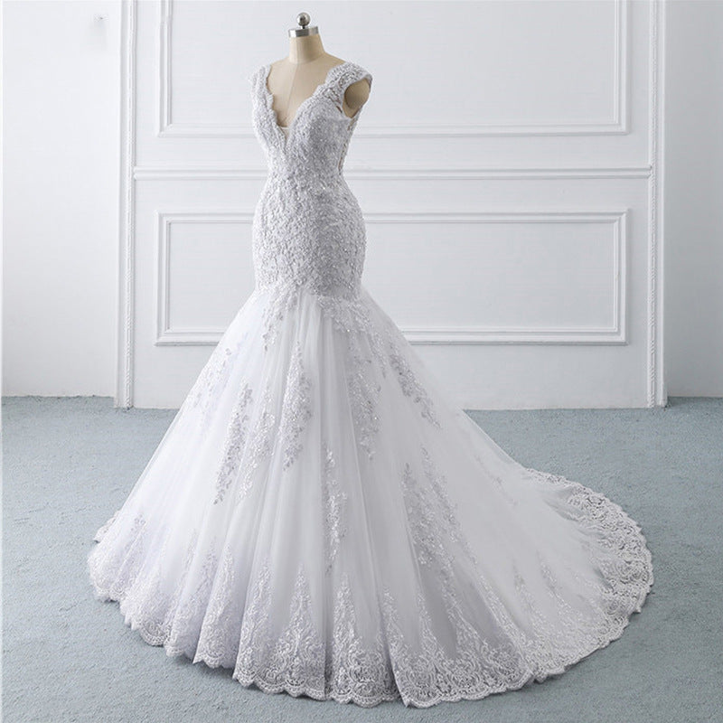 A luxurious mermaid wedding dress with a light trailing train, French retro design, and delicate lace details, perfect for an elegant and slim bridal look.

