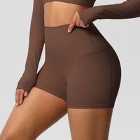 Brown athletic outfit with shorts and long-sleeve top on a plain background